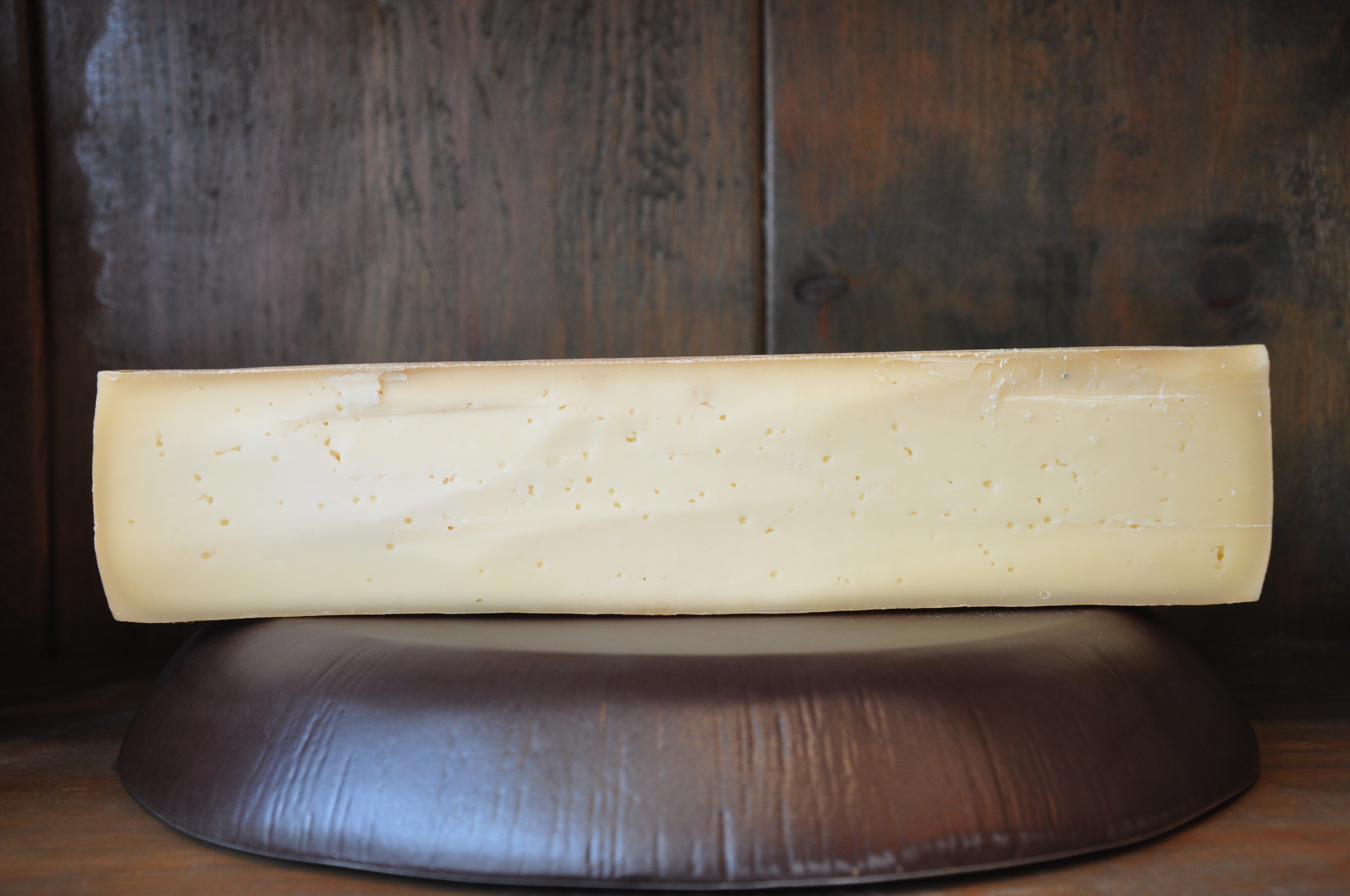 Wheel of Little Mountain Alpine-style cheese on a wooden board